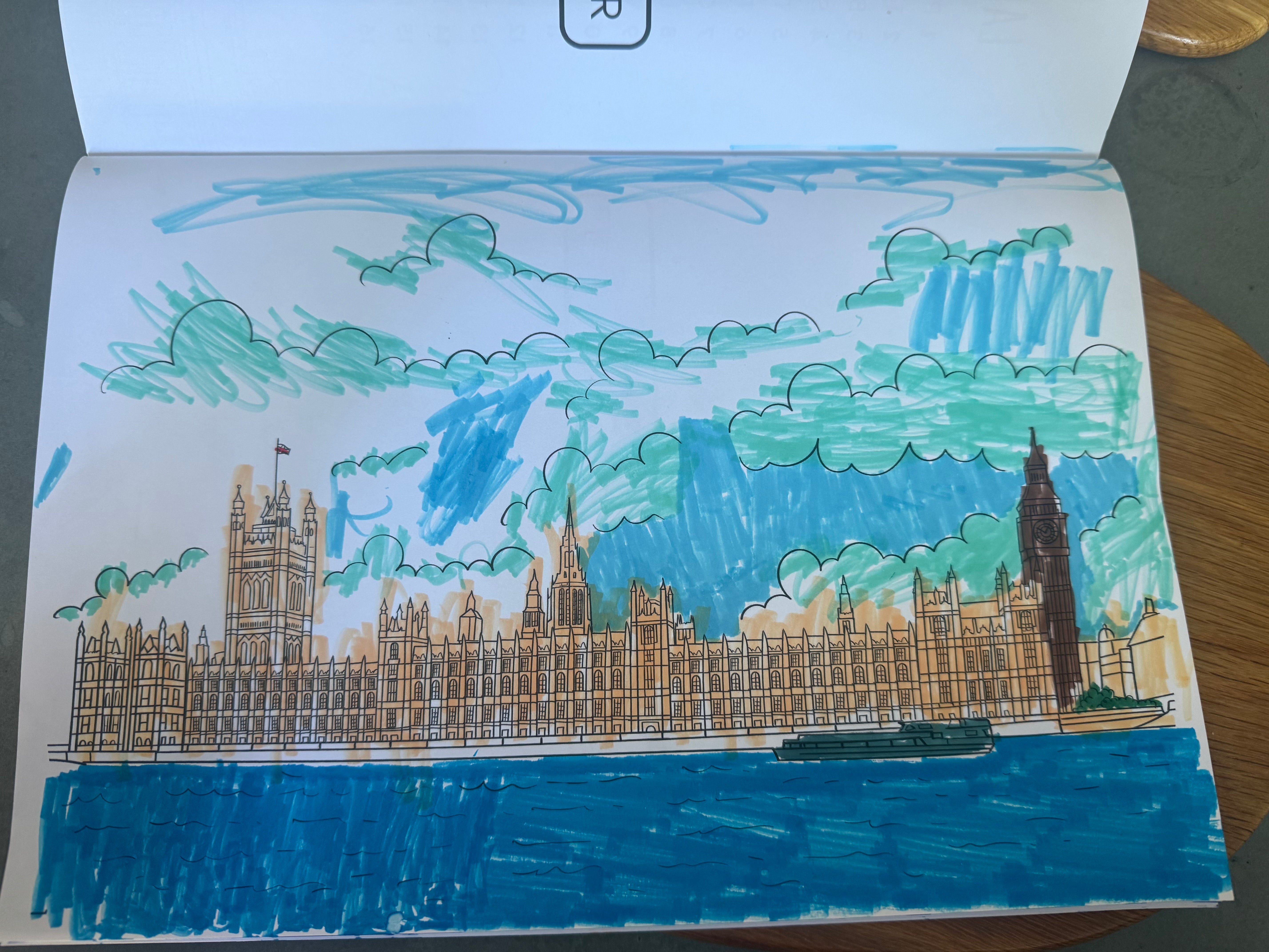 Colorful drawing of Palace of Westminster with buildings and clouds on a piece of paper.