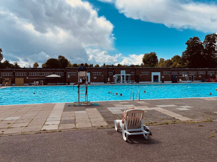 a person sitting in a chair next to a pool